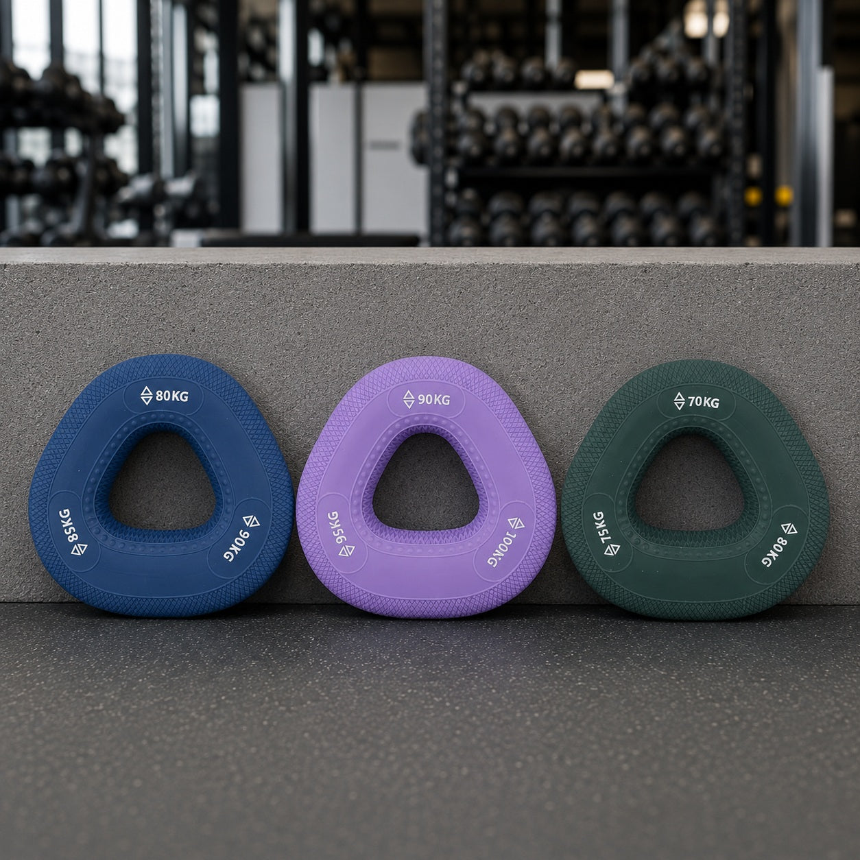 Musclet trois modèles de couleurs appuyé sur une surface de gym