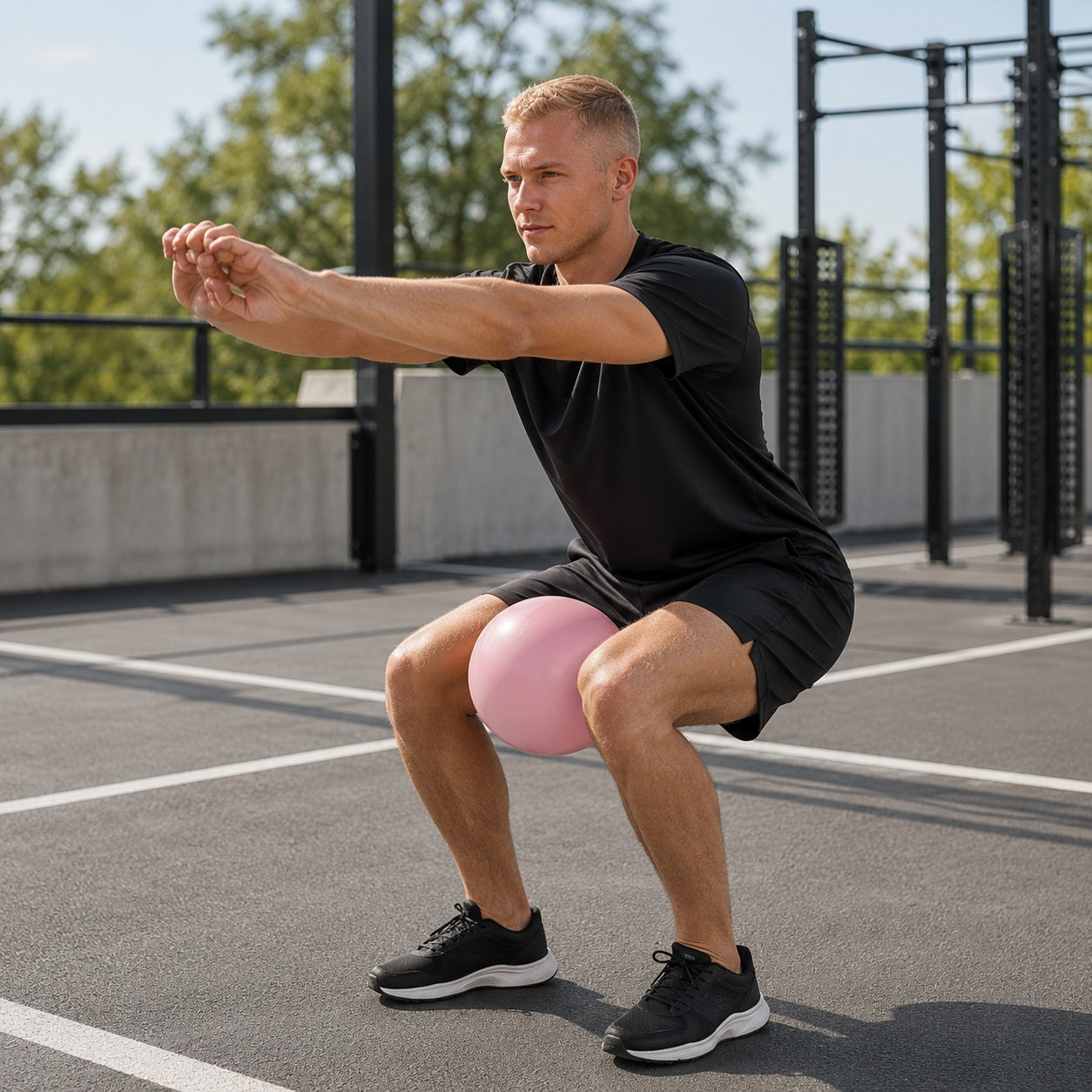 Ballon musculation une personne pratique les squat avec l'accessoire dans un espace entraînement extérieur