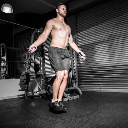 Corde à sauter homme saute rapidement au gym