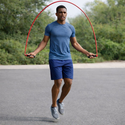 Corde à sauter sport homme pratique dehors devant un boisé