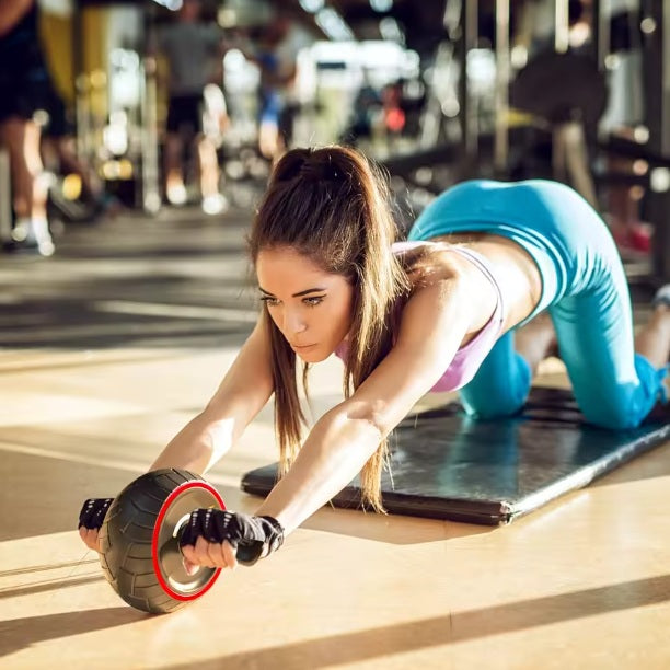 Roue abdominale une personne en salle de sport utilisant le matériel d'entraînement