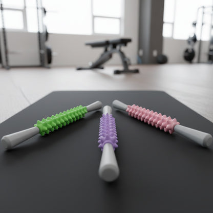 Rouleau de massage les trois modèles de couleurs placé sur un tapis d'entraînement dans un espace fitness