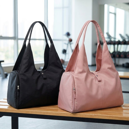 Sac de sport femme les deux modèles de couleurs sont déposés sur un banc de salle de gym donnant face à une grande fenestration
